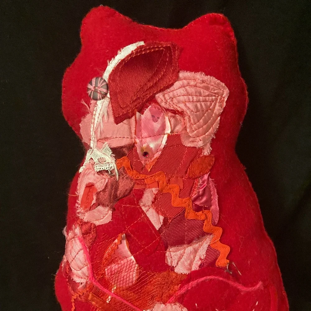 Felted cat pillow with apliqued and stitched designs. Vintage fabric and button.